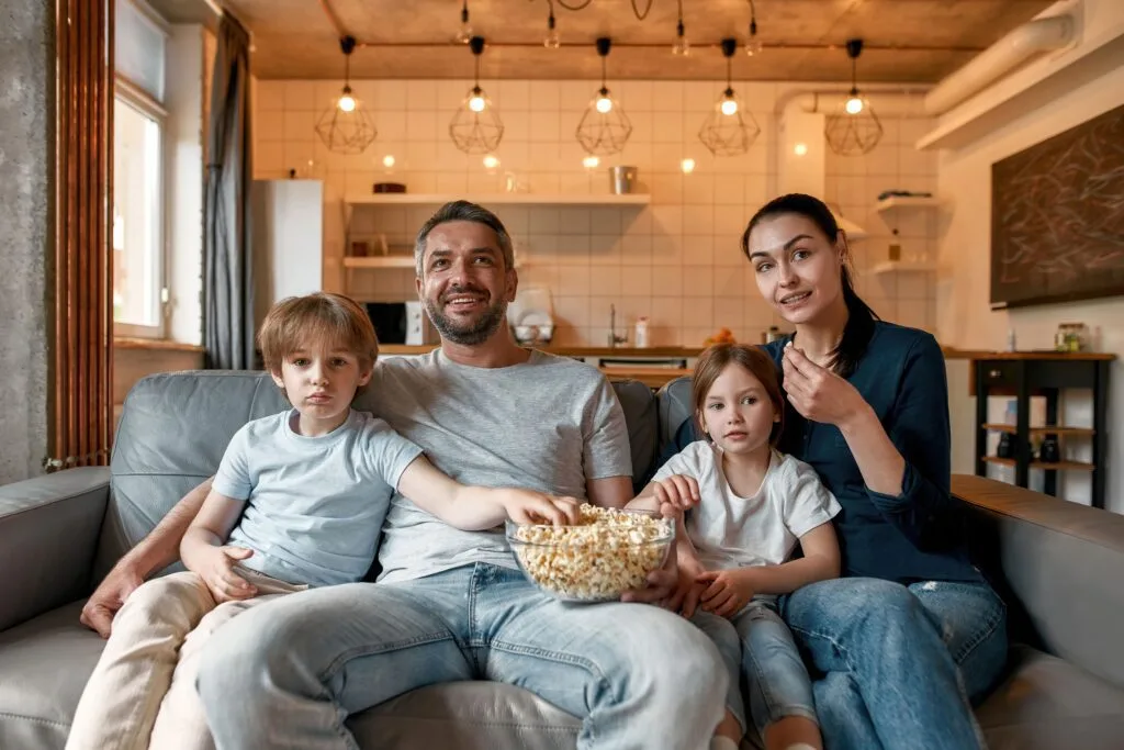 A family with popcorn watching TV together at home